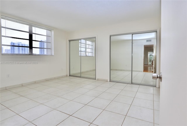 2920 Point E Dr Unit N208, Aventura, FL 33160 - unfurnished bedroom featuring two closets and light tile patterned floors