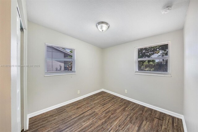 3818 Everglades Rd, Palm Beach Gardens, FL 33410 - empty room with dark wood-type flooring, plenty of natural light, and a smoke detector