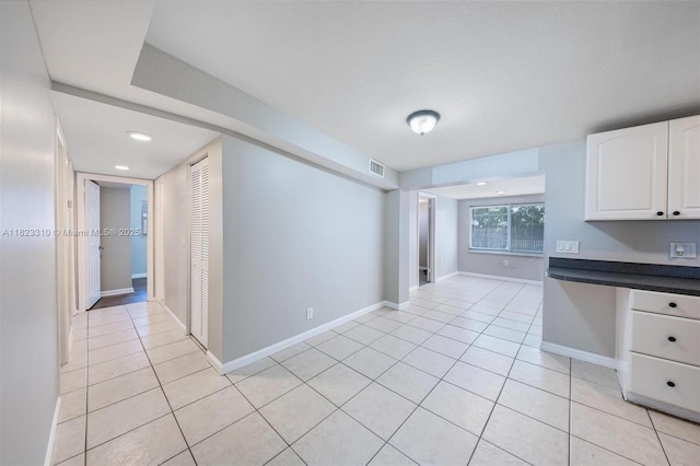 3818 Everglades Rd, Palm Beach Gardens, FL 33410 - kitchen featuring white cabinets, light tile patterned flooring, and dark countertops