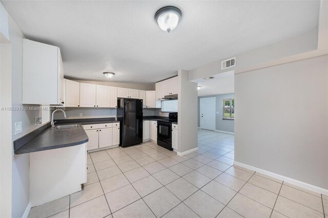 3818 Everglades Rd, Palm Beach Gardens, FL 33410 - kitchen with black appliances, dark countertops, light tile patterned floors, and white cabinets