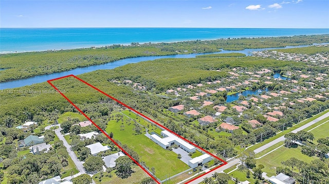 9741 SE Gomez Ave, Hobe Sound, FL 33455 - aerial perspective of suburban area featuring property parcel outlined and a large body of water