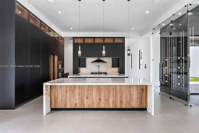 9741 SE Gomez Ave, Hobe Sound, FL 33455 - kitchen featuring modern cabinets, decorative backsplash, recessed lighting, a spacious island, and light stone counters