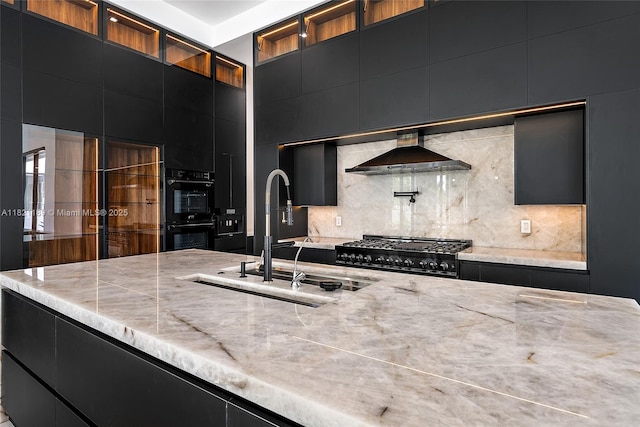 9741 SE Gomez Ave, Hobe Sound, FL 33455 - kitchen with dark cabinetry, wall chimney exhaust hood, range, and decorative backsplash