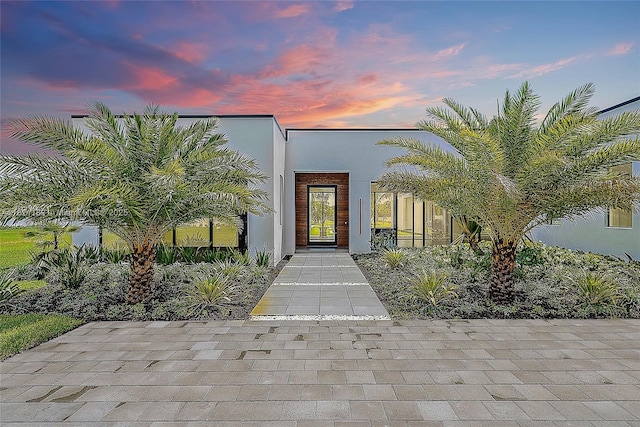 9741 SE Gomez Ave, Hobe Sound, FL 33455 - exterior entry at dusk with stucco siding
