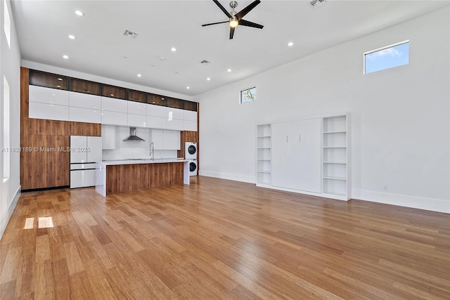 9741 SE Gomez Ave, Hobe Sound, FL 33455 - unfurnished living room featuring a high ceiling, light wood finished floors, recessed lighting, a ceiling fan, and built in shelves