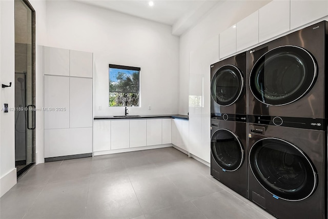 9741 SE Gomez Ave, Hobe Sound, FL 33455 - laundry room featuring stacked washer / dryer, cabinet space, washer and clothes dryer, and a high ceiling