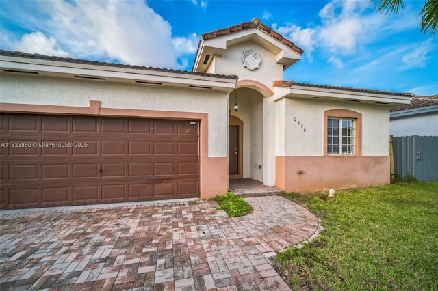 10870 SW 229th St, Miami, FL 33170 - mediterranean / spanish-style house with stucco siding, decorative driveway, a front yard, a garage, and a tiled roof