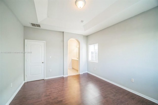 10870 SW 229th St, Miami, FL 33170 - unfurnished bedroom featuring arched walkways, a raised ceiling, wood finished floors, and ensuite bathroom