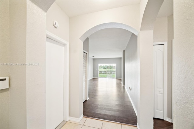 10870 SW 229th St, Miami, FL 33170 - hallway featuring arched walkways, tile patterned floors, and a textured wall