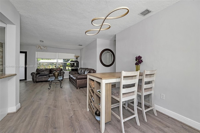 5576 SW 7th St, Margate, FL 33068 - dining area featuring wood finished floors, a textured ceiling, and a chandelier
