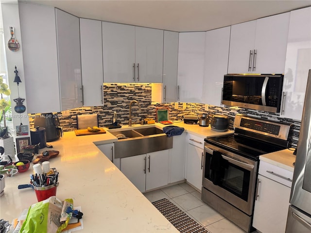 2750 NE 183rd St Unit 2103, Aventura, FL 33160 - kitchen featuring appliances with stainless steel finishes, light countertops, decorative backsplash, and white cabinets