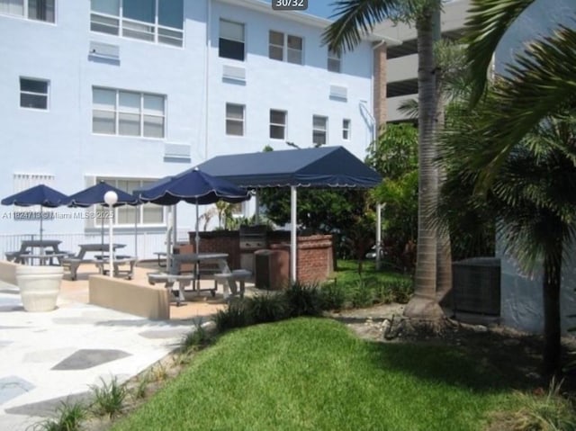 326 Harrison St Unit 303A, Hollywood, FL 33019 - surrounding community with a patio area and a lawn