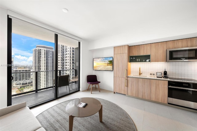 601 NE 1st Ave Unit 2703, Miami, FL 33132 - kitchen with stainless steel microwave, wall oven, tasteful backsplash, modern cabinets, and expansive windows