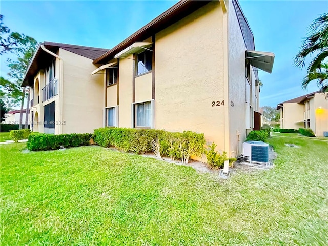 224 Pine Hov Cir Unit D-2, Green Acres, FL 33463 - view of side of property featuring stucco siding and a lawn
