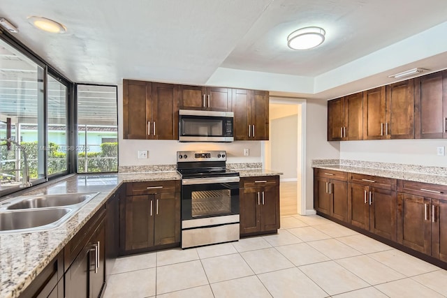 1708 NW 84th Dr, Coral Springs, FL 33071 - kitchen with appliances with stainless steel finishes, light tile patterned floors, and dark brown cabinets