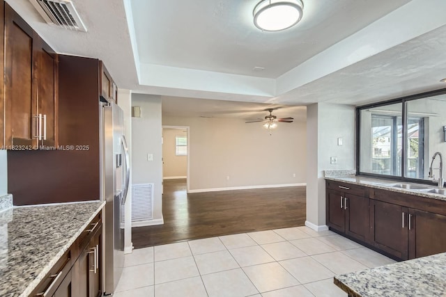 1708 NW 84th Dr, Coral Springs, FL 33071 - kitchen featuring a raised ceiling, light stone countertops, open floor plan, ceiling fan, and light tile patterned floors