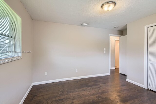 1708 NW 84th Dr, Coral Springs, FL 33071 - unfurnished bedroom featuring dark wood-style flooring, a closet, and a textured ceiling