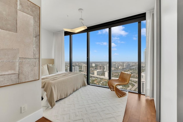 18555 Collins Ave Unit 4605, Sunny Isles Beach, FL 33160 - bedroom featuring floor to ceiling windows, multiple windows, wood finished floors, and a view of city