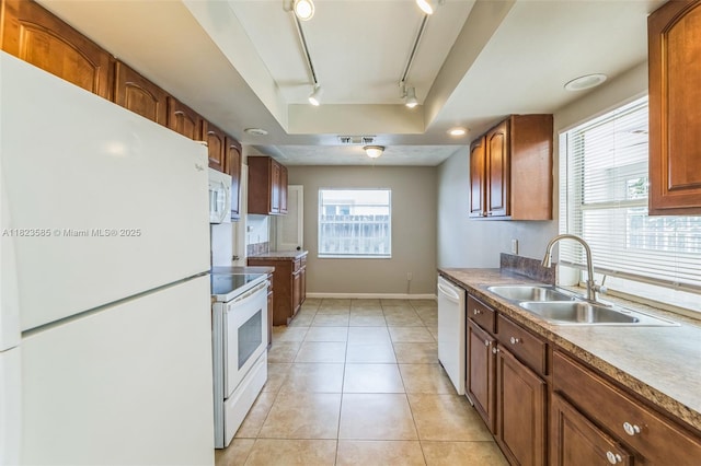 22226 SW 62nd Ave, Boca Raton, FL 33428 - kitchen featuring white appliances, track lighting, light tile patterned floors, and brown cabinetry