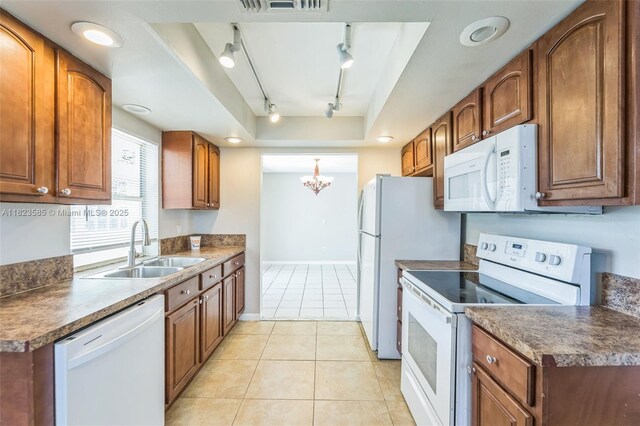22226 SW 62nd Ave, Boca Raton, FL 33428 - kitchen with white appliances, track lighting, brown cabinets, a chandelier, and light tile patterned floors