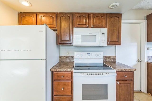 22226 SW 62nd Ave, Boca Raton, FL 33428 - kitchen with white appliances, brown cabinets, and dark countertops