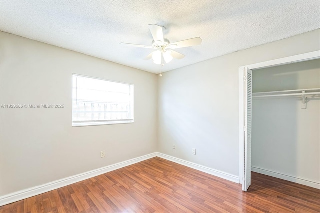 22226 SW 62nd Ave, Boca Raton, FL 33428 - unfurnished bedroom featuring a closet, wood finished floors, a textured ceiling, and a ceiling fan