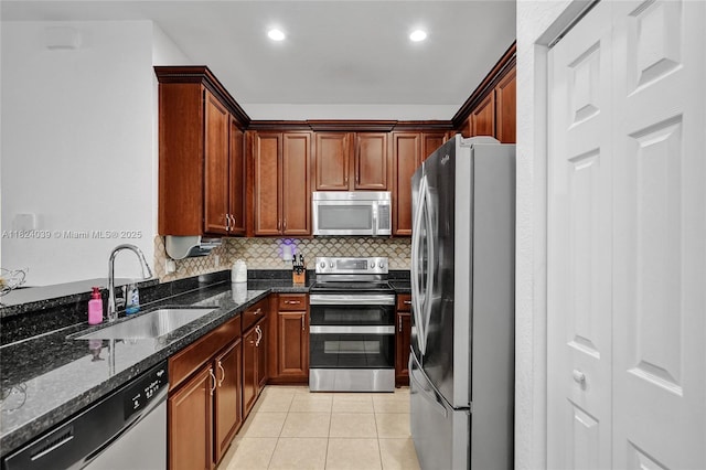 11854 SW 27th St, Miramar, FL 33025 - kitchen with stainless steel appliances, tasteful backsplash, dark stone counters, light tile patterned floors, and recessed lighting