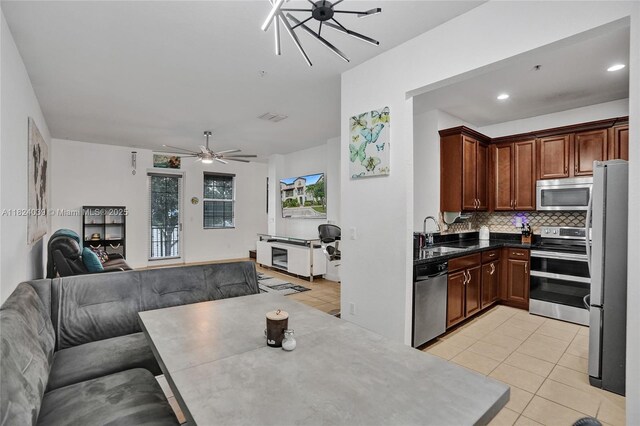 11854 SW 27th St, Miramar, FL 33025 - kitchen with stainless steel appliances, open floor plan, decorative backsplash, light tile patterned floors, and ceiling fan