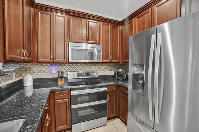 11854 SW 27th St, Miramar, FL 33025 - kitchen featuring appliances with stainless steel finishes, light tile patterned flooring, backsplash, and dark stone counters