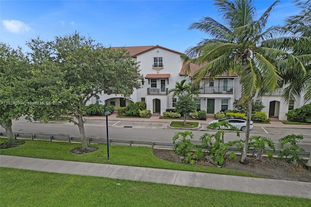 11854 SW 27th St, Miramar, FL 33025 - view of front of house with stucco siding, a balcony, and a front lawn