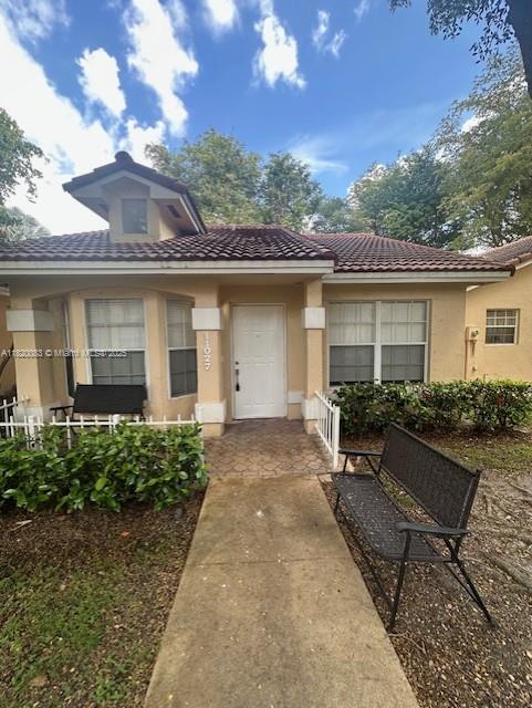 11027 SW 152nd Ct, Miami, FL 33196 - view of exterior entry with a tile roof and stucco siding