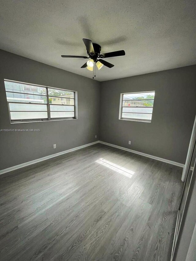 3515 Van Buren St Unit 106, Hollywood, FL 33021 - empty room featuring plenty of natural light, a textured ceiling, wood finished floors, and a ceiling fan