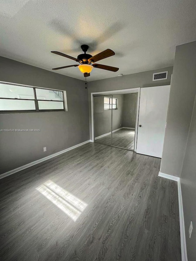 3515 Van Buren St Unit 106, Hollywood, FL 33021 - unfurnished bedroom with wood finished floors, a textured ceiling, a closet, and ceiling fan