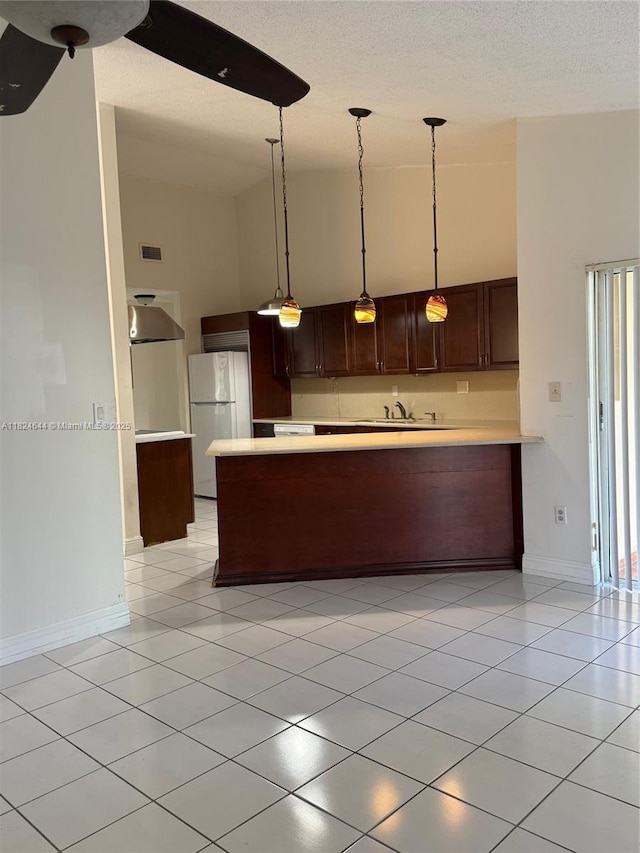 651 NW 134th Ave, Miami, FL 33182 - kitchen with freestanding refrigerator, light countertops, light tile patterned floors, a high ceiling, and a peninsula