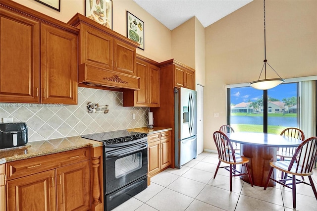 3128 Peachtree Cir, Davie, FL 33328 - kitchen featuring black electric range, stainless steel fridge with ice dispenser, brown cabinetry, decorative backsplash, and high vaulted ceiling
