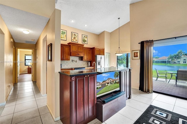 3128 Peachtree Cir, Davie, FL 33328 - kitchen with stainless steel fridge, dark countertops, a textured ceiling, decorative backsplash, and light tile patterned floors