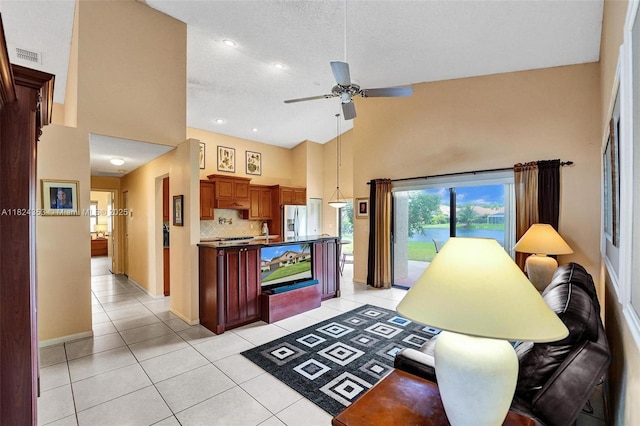 3128 Peachtree Cir, Davie, FL 33328 - kitchen with stainless steel refrigerator with ice dispenser, ceiling fan, high vaulted ceiling, light tile patterned floors, and tasteful backsplash