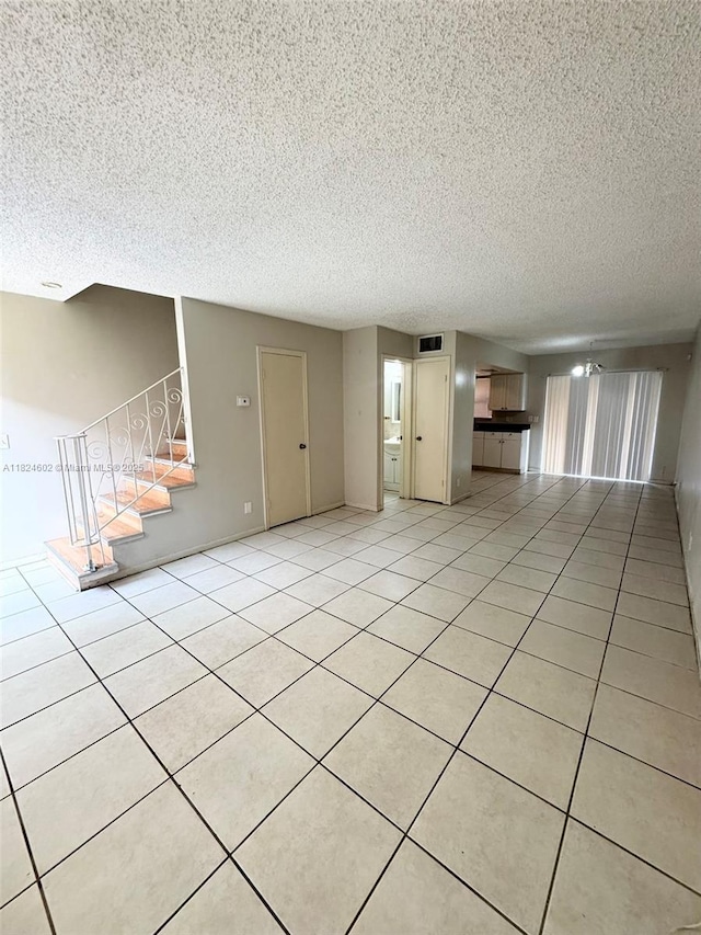 2562 NW 52nd Ave Unit B18, Lauderhill, FL 33313 - unfurnished living room featuring stairway, a textured ceiling, and light tile patterned flooring