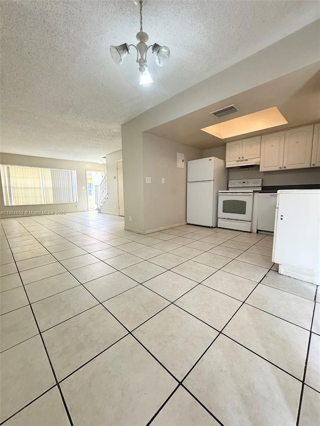 2562 NW 52nd Ave Unit B18, Lauderhill, FL 33313 - kitchen featuring white appliances, a textured ceiling, light tile patterned floors, a chandelier, and under cabinet range hood