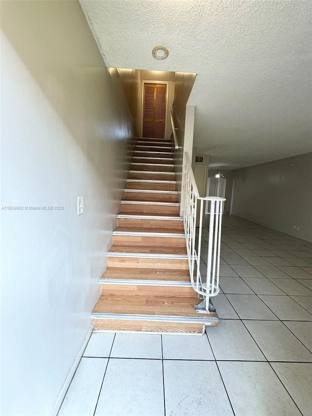 2562 NW 52nd Ave Unit B18, Lauderhill, FL 33313 - stairway featuring tile patterned floors and a textured ceiling