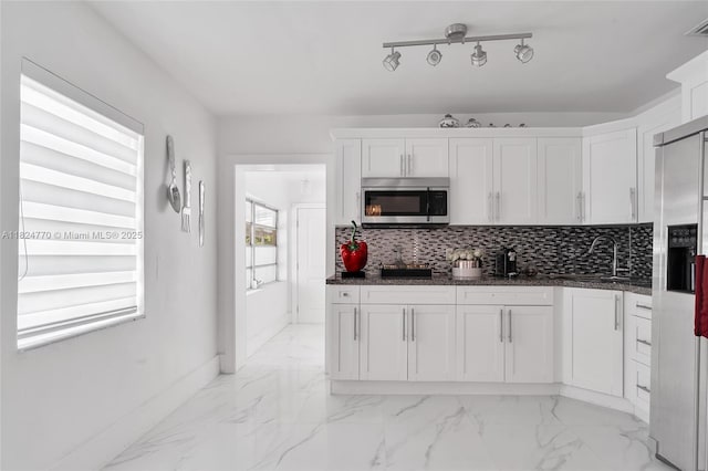 31 SW 58th Ct, Miami, FL 33144 - kitchen featuring stainless steel appliances, white cabinetry, light marble finish floors, and decorative backsplash