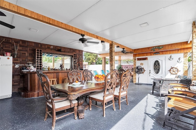 31 SW 58th Ct, Miami, FL 33144 - dining room featuring a ceiling fan, wood walls, and a dry bar