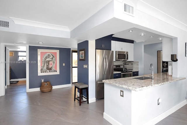 104500 Overseas Hwy, Key Largo, FL 33037 - kitchen with stainless steel appliances, a peninsula, decorative backsplash, a raised ceiling, and light stone counters