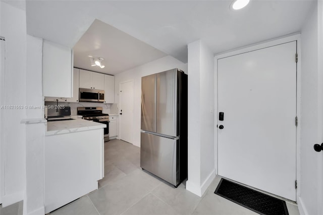 6900 N Kendall Dr Unit A303, Pinecrest, FL 33156 - kitchen with appliances with stainless steel finishes, white cabinets, light stone counters, and light tile patterned flooring