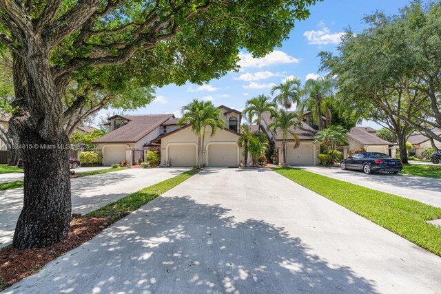 10091 SW 137th Pl, Miami, FL 33186 - view of front of house featuring stucco siding, an attached garage, concrete driveway, and a residential view