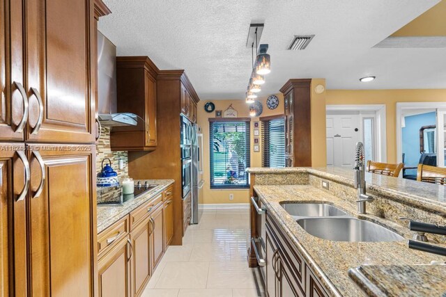 10091 SW 137th Pl, Miami, FL 33186 - kitchen with black electric cooktop, light stone counters, light tile patterned floors, wall chimney range hood, and a textured ceiling