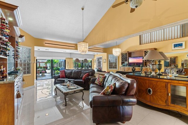 10091 SW 137th Pl, Miami, FL 33186 - living room with light tile patterned floors, a ceiling fan, a textured ceiling, and high vaulted ceiling