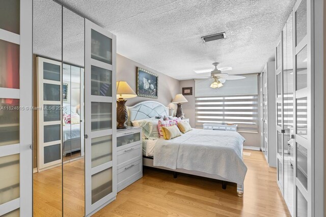 10091 SW 137th Pl, Miami, FL 33186 - bedroom with light wood finished floors, a textured ceiling, and a ceiling fan