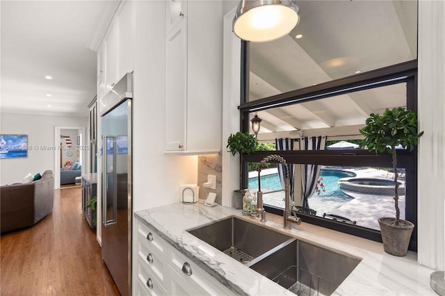 1460 Mantua Ave, Coral Gables, FL 33146 - kitchen with white cabinets, stainless steel built in refrigerator, light stone countertops, wood finished floors, and recessed lighting