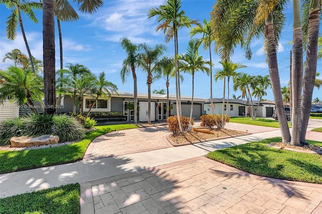 501 SE 7th Ave, Pompano Beach, FL 33060 - view of front of property with decorative driveway, a garage, a front yard, stucco siding, and french doors